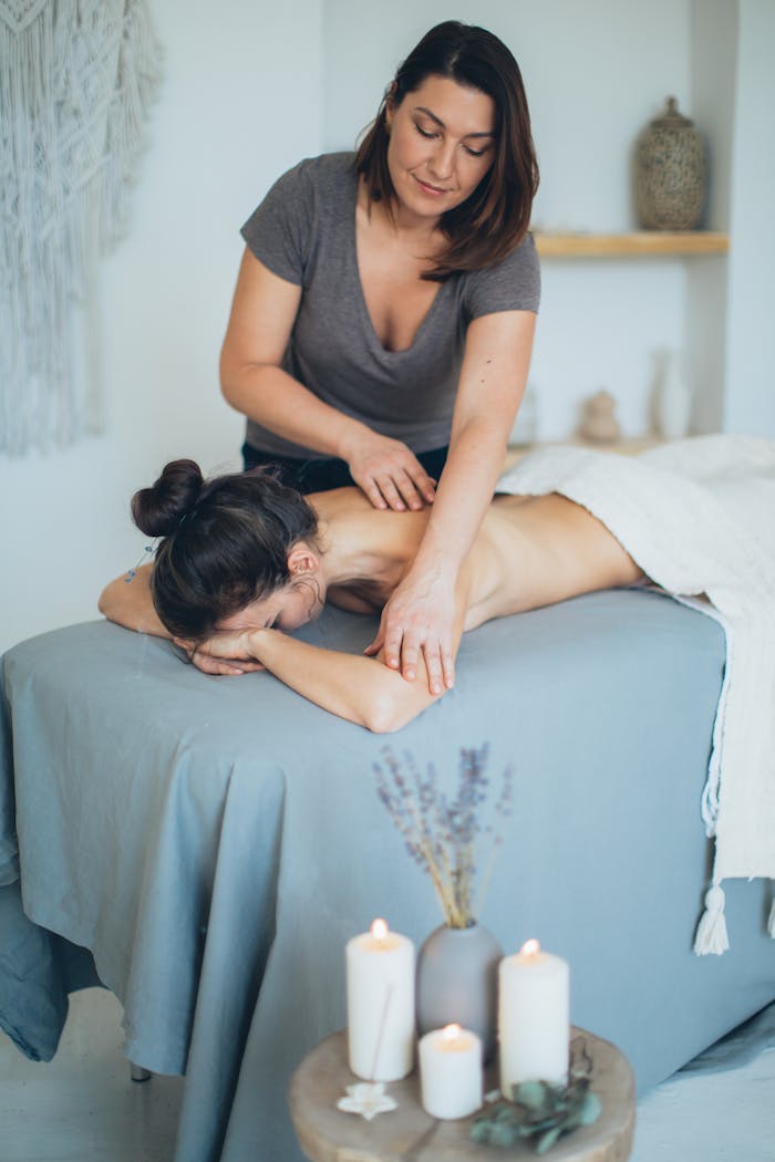 gallery-3 A serene spa setting with a therapist giving a back massage to a female client for relaxation.
