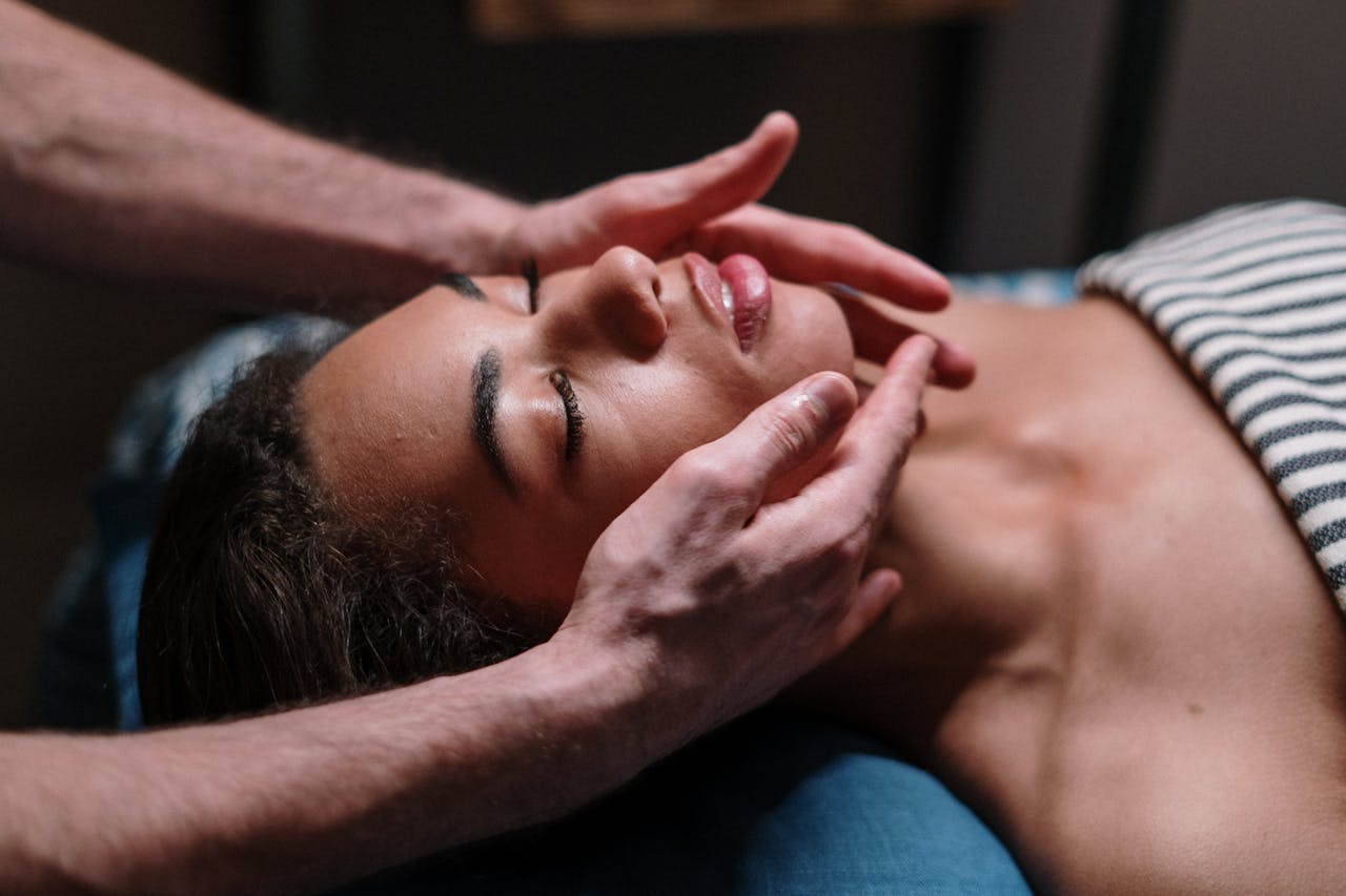 gallery-5 Close-up of a woman receiving a soothing facial massage in a serene spa environment.