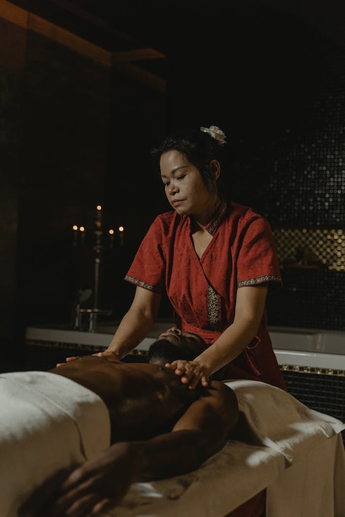 services-04 Experience a calming massage from an expert masseuse in a dimly lit spa for total relaxation.